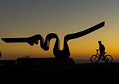 Silhoutte photo of a person walking their bike near the Porter Squiggle