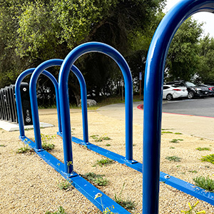 Image of four blue, u-shaped bike racks