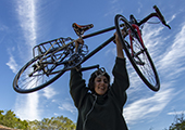 photo of a person holding a bike in the air with link